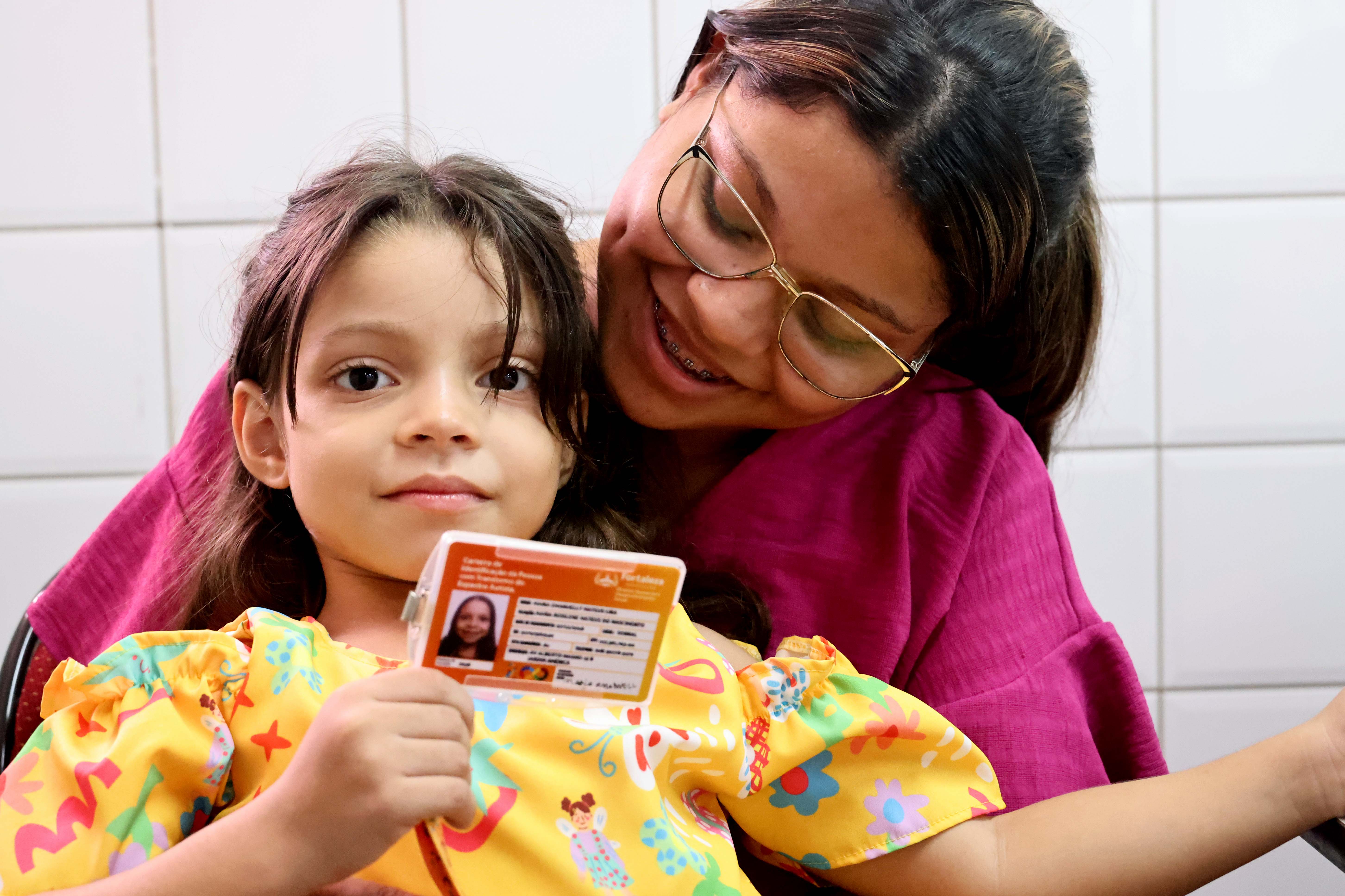 mãe com criança segurando cartão